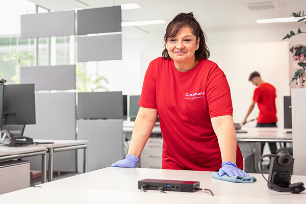 We offer a wide range of jobs in the cleaning services field. Dussmann employee from the cleaning services division cleaning an office desk.